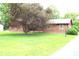 Charming brick home with large tree in the front yard and sidewalk leading to the street at 7931 Guion Rd, Indianapolis, IN 46268