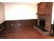 Warm living room features a brick fireplace, dark wood paneling and hardwood floors at 7931 Guion Rd, Indianapolis, IN 46268