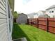 A fenced backyard with a green lawn features a shed for storage and a ladder hanging on the fence at 8346 Weathervane Cir, Indianapolis, IN 46239