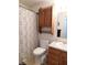 Cozy bathroom with wood cabinet, grey patterned shower curtain and modern toilet at 8346 Weathervane Cir, Indianapolis, IN 46239