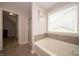 Relaxing bathroom featuring a large bathtub with tile surround and natural light from window at 8710 N Aspen Way, McCordsville, IN 46055