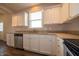 Well-lit kitchen with stainless steel dishwasher, granite countertops, white cabinets, and a bright window at 8710 N Aspen Way, McCordsville, IN 46055