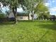 Large grassy backyard with trees. The house has beige vinyl siding, a chimney, and a patio at 892 Millbrook Dr, Avon, IN 46123