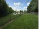 Fenced-in backyard with lush green lawn and scenic pond at 892 Millbrook Dr, Avon, IN 46123