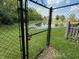 View of backyard pond through black chain link fence at 892 Millbrook Dr, Avon, IN 46123