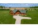 An aerial view reveals the log home set in a large manicured lawn with an expansive farm field beyond at 8981 N 325 E, Columbus, IN 47203