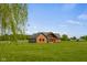 Attractive log home in a sprawling yard, showcasing its unique architectural design and green trim at 8981 N 325 E, Columbus, IN 47203