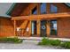 Inviting front porch featuring chairs, with the log home's entrance visible at 8981 N 325 E, Columbus, IN 47203