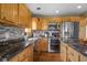 Well-lit kitchen with stainless appliances, wooden cabinetry, and backsplash tiling at 8981 N 325 E, Columbus, IN 47203