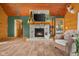Warm living room featuring a stone fireplace, log walls, and comfortable furnishings at 8981 N 325 E, Columbus, IN 47203