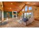 Spacious living area with stone fireplace, hardwood floors, log walls, and vaulted ceiling at 8981 N 325 E, Columbus, IN 47203