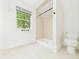 Bright bathroom featuring tiled shower stall, tiled floors, and window for natural light at 907 S A St, Elwood, IN 46036