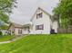 A quaint home with a well-manicured lawn and a charming enclosed front porch at 907 S A St, Elwood, IN 46036