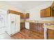 A cozy kitchen features wood cabinets, white appliances, and hardwood floors at 907 S A St, Elwood, IN 46036