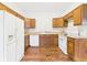 An inviting kitchen includes wood cabinets, white appliances, and hardwood floors at 907 S A St, Elwood, IN 46036
