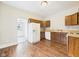 A kitchen showcases wood cabinets, white appliances, and hardwood floors connecting to a doorway at 907 S A St, Elwood, IN 46036