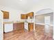 A kitchen features warm cabinets, white appliances, and hardwood floors adding character and functionality at 907 S A St, Elwood, IN 46036