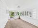 Sun-drenched porch featuring all-white decor, carpeted floor, and multiple windows at 907 S A St, Elwood, IN 46036