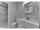 Well-lit bathroom features a modern vanity with a square mirror and a toilet with a closet behind it at 9317 E 36Th Pl, Indianapolis, IN 46235