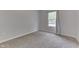 Well-lit bedroom with light gray walls and neutral carpet features a single window with white curtains at 9317 E 36Th Pl, Indianapolis, IN 46235