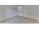 Empty bedroom with carpet and light gray walls, multiple doors, and glimpses into the hallway at 9317 E 36Th Pl, Indianapolis, IN 46235