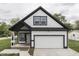 Charming two-story home with a white exterior, black trim, a garage, and a well-manicured front lawn at 9317 E 36Th Pl, Indianapolis, IN 46235
