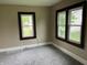 Cozy bedroom featuring neutral walls, plush gray carpet, and natural light streaming through two windows at 1020 E 30Th St, Anderson, IN 46016