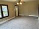 Neutral carpeted living room with abundant natural light and ceiling fan at 1020 E 30Th St, Anderson, IN 46016