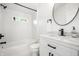 Stylish bathroom with a shower-tub, marble countertop vanity, and round mirror at 1034 N Tacoma Ave, Indianapolis, IN 46201
