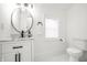 Clean bathroom featuring modern fixtures, a marble countertop vanity, and a round mirror at 1034 N Tacoma Ave, Indianapolis, IN 46201