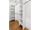 Walk-in closet with custom white shelving and wood floor perfect for storage at 1034 N Tacoma Ave, Indianapolis, IN 46201