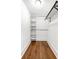 Walk-in closet showcasing hardwood floors, custom shelving, and hanging rods at 1034 N Tacoma Ave, Indianapolis, IN 46201