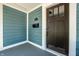 Close-up of a front porch with blue siding, a dark wood door, and a keypad lock at 1034 N Tacoma Ave, Indianapolis, IN 46201