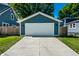 A detached one-car garage with teal siding and a white door offers convenient parking and storage space at 1034 N Tacoma Ave, Indianapolis, IN 46201