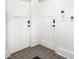Hallway with two white doors, tiled flooring, and light switches on the wall at 1034 N Tacoma Ave, Indianapolis, IN 46201