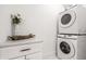 Laundry room features a stacked washer and dryer with a counter and decor at 1034 N Tacoma Ave, Indianapolis, IN 46201