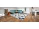 Bright living room featuring hardwood floors, area rug, and comfortable turquoise sofa at 1034 N Tacoma Ave, Indianapolis, IN 46201
