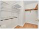 Walk-in closet features multiple white shelving units and a wooden rod at 10717 Morristown Ct, Carmel, IN 46032