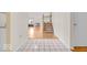 Bright foyer with tile flooring that transitions to wood flooring, leading to a staircase and an open living area at 10717 Morristown Ct, Carmel, IN 46032
