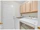 Laundry room featuring a washer, dryer, white cabinets and door leading outside at 10717 Morristown Ct, Carmel, IN 46032