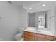 Bright bathroom with a classic vanity, white toilet, and clear, glass-doored shower at 11065 Spice Ln, Fishers, IN 46037