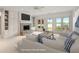 Cozy living room with a stone fireplace, built-in cabinets, and scenic water views through large windows at 11065 Spice Ln, Fishers, IN 46037