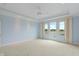 Bright main bedroom features large windows overlooking lake and tray ceiling at 11065 Spice Ln, Fishers, IN 46037
