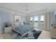 Serene main bedroom with blue walls, tray ceiling, and a large window overlooking the water at 11065 Spice Ln, Fishers, IN 46037