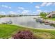 Panoramic waterfront view from a backyard, featuring well-maintained boat docks, lush lawn, and community homes at 11065 Spice Ln, Fishers, IN 46037