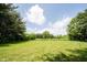 Expansive backyard with lush lawn, mature trees, and plenty of space for outdoor activities at 11423 Atlantic Rd, Fortville, IN 46040