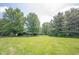 Expansive backyard with mature trees and a well-manicured lawn, offering a serene and private outdoor space at 11423 Atlantic Rd, Fortville, IN 46040