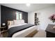 Modern bedroom featuring a platform bed, dark accent wall, and natural light from the window at 11423 Atlantic Rd, Fortville, IN 46040