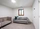 Neutral bedroom with a gray couch and crib below a round ceiling light at 11423 Atlantic Rd, Fortville, IN 46040