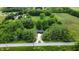 Aerial view of a modern home surrounded by lush greenery, with a long driveway leading to the street at 11423 Atlantic Rd, Fortville, IN 46040